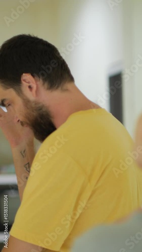 Angry bearded man arguing indoors, gesturing with frustration