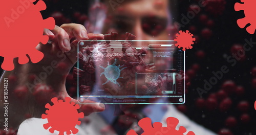 Image of coronavirus cells over male doctor holding clear tablet processing data about cell