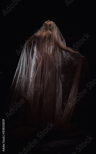 Beautiful blonde woman posing in brown veil by candlelight on dark background, gothic queen, art style..
