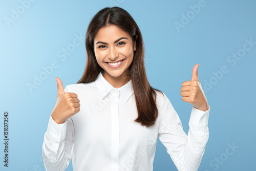A woman in a white shirt smiles and gives two thumbs up against a blue background.