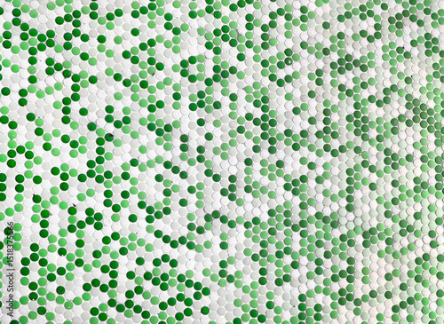detailed view of a surface covered in a mosaic pattern composed of numerous small, circular tiles in varying shades of  green and white, creating a textured for design in architecture.