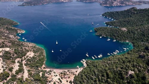 Aerial view of sailing boats navigating the turquoise waters of Sarsala Bay, surrounded by lush green forest