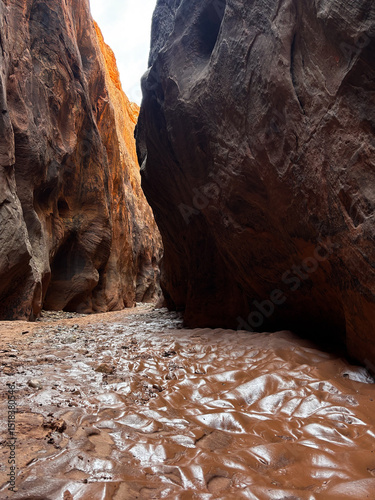hiking trail through tall red sandstone cliffs and slot canyon of Buckskin Gulch from Wire Pass in the backcountry of southern Utah