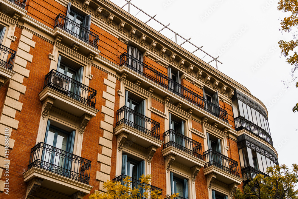 Obraz premium Charming residential building in Madrid featuring classic balconies and elegant architecture.