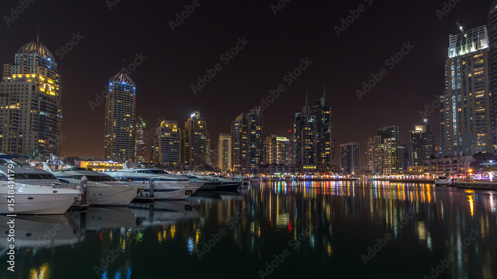 Fototapeta premium Dubai marina bay with yachts an boats night timelapse hyperlapse