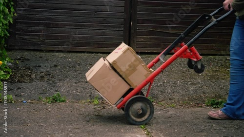 Woman with delivery of cardboard boxes and trolley cart 