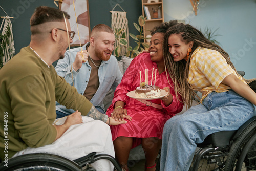 Diverse group of young adults with disability celebrating birthday, smiling and laughing together while holding cake with candles, woman surrounded by friends photo