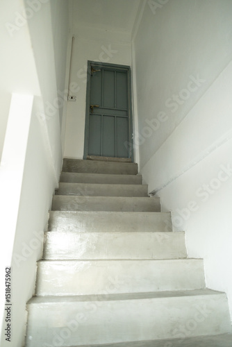 A warm ray of sunlight pours across the staircase, guiding the way to the floor above.