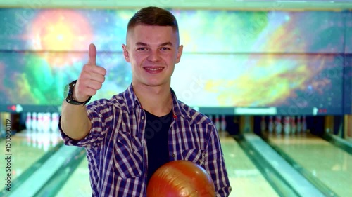 Brunette guy gives a thumbs up for bowling fun