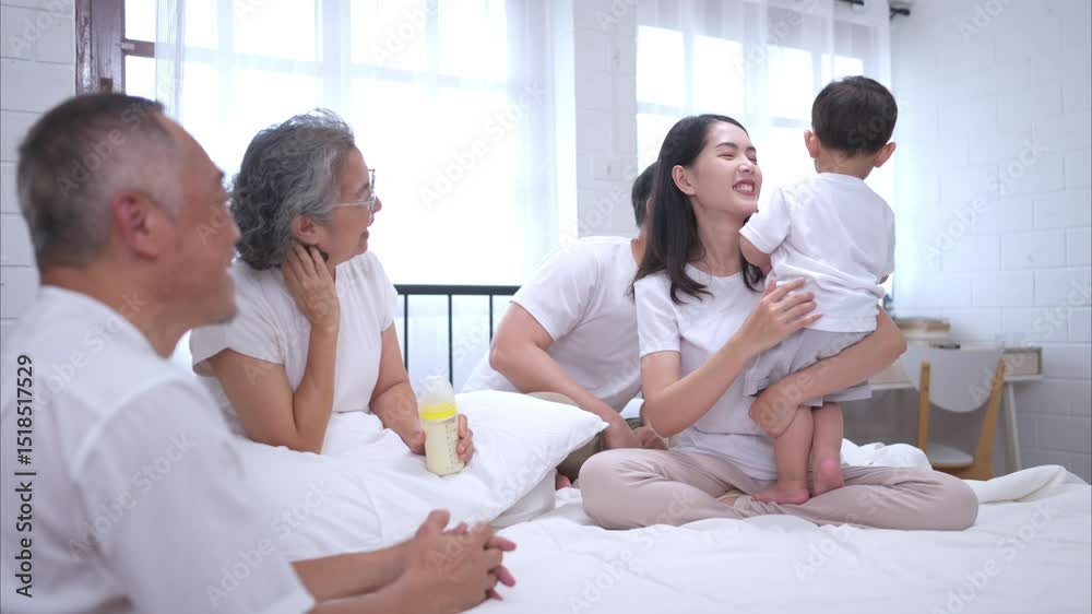 Before putting the kids to bed, parents, grandparents, and kid unwind and play in the bedroom Before putting the kids to bed, parents, grandparents, and kid unwind and play in the bedroom