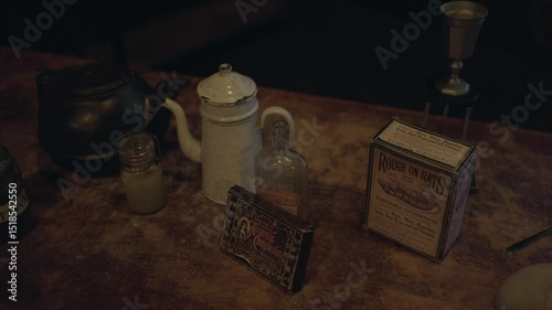 This panning video captures a moody turn-of-the-century table scene, covered with historically inspired items suggesting poison and murderous intent. 