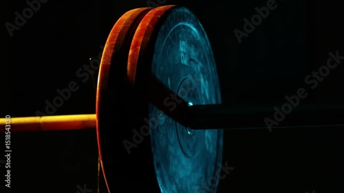 Athlete's chalked hands load heavy weight plates onto a barbell. Preparing for a workout, this close-up of worn gym equipment is ideal for fitness, strength training, and bodybuilding content.