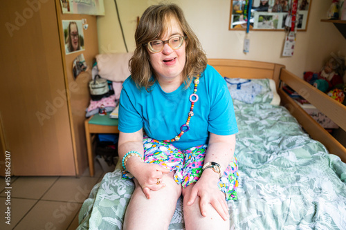 Portrait of a 42 yo happy woman with Down Syndrome in her sleeping room in Tienen, Flemish Brabant Region, Belgium