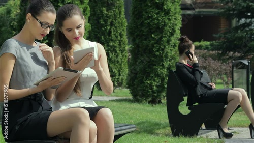 Businesswomen engaged in a deal while one receives a call