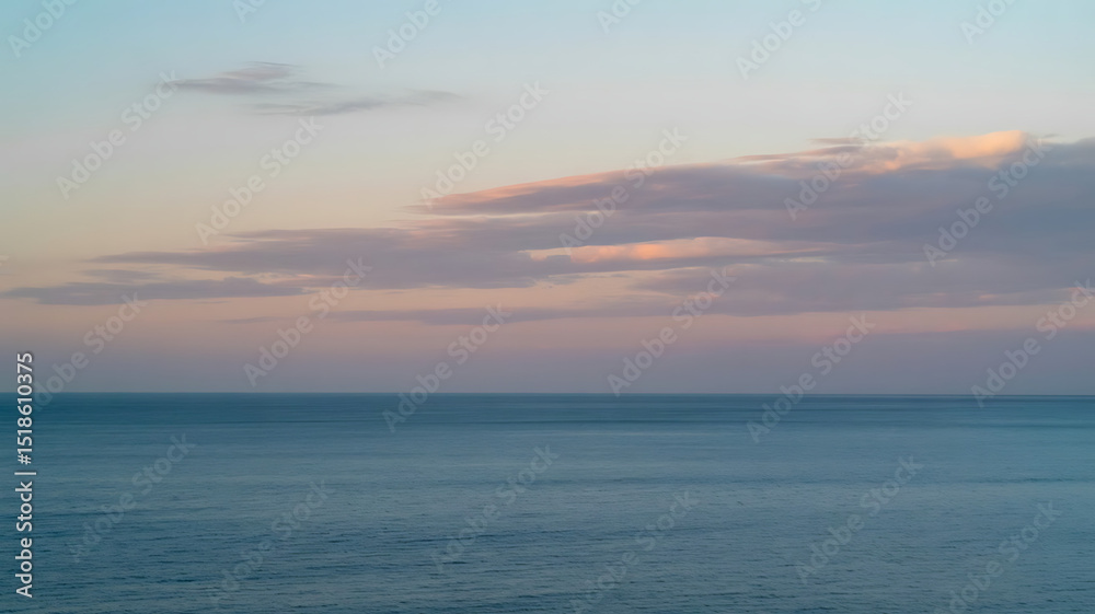 Obraz premium The calm ocean meets a pastel sky during a peaceful, colorful sunset.