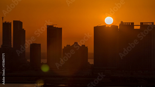 Buildings on Al Reem island in Abu Dhabi at sunset timelapse from above.