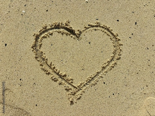 Heart in the yellow sand isolated close-up in Fuerteventura, Canary Islands, Spain, romantic vacations