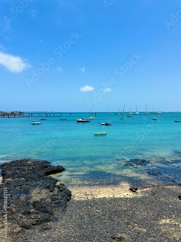 Turquoise ocean water of Corralejo harbor in Fuerteventura, Canary Islands, Spain, summer time, vertical photo