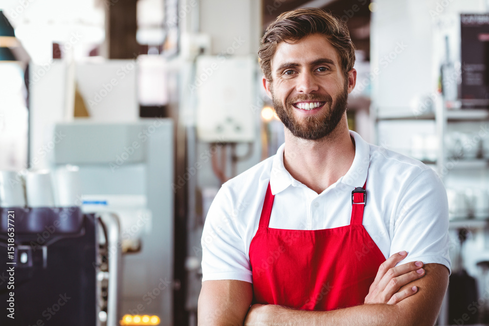 Fototapeta premium Man wearing red apron smiling beside coffee machine in coffee shop kitchen, copy space