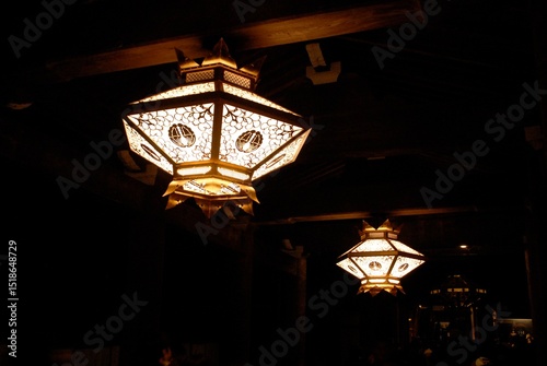 日本の伝統的な灯篭が灯る夜の寺院の風景
