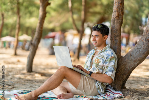 Asian man remote working corporate business on laptop computer while travel the sea on summer beach holiday vacation. Workation, work from anywhere with wireless technology and digital gadget device.