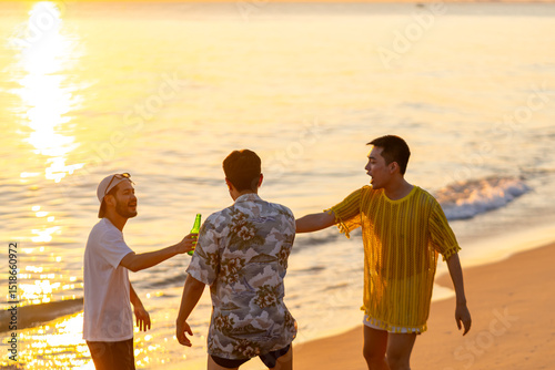 Happy Asian man travel nature the sea drinking beer on the beach on summer holiday vacation. Group of People friends enjoy and fun outdoor lifestyle celebration party on tropical beach at sunset.