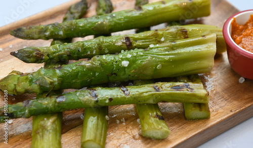 Grilled asparagus on a wooden board, close up