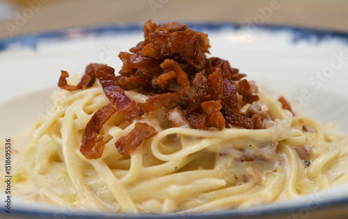 Spaghetti carbonara with bacon on a plate, close-up