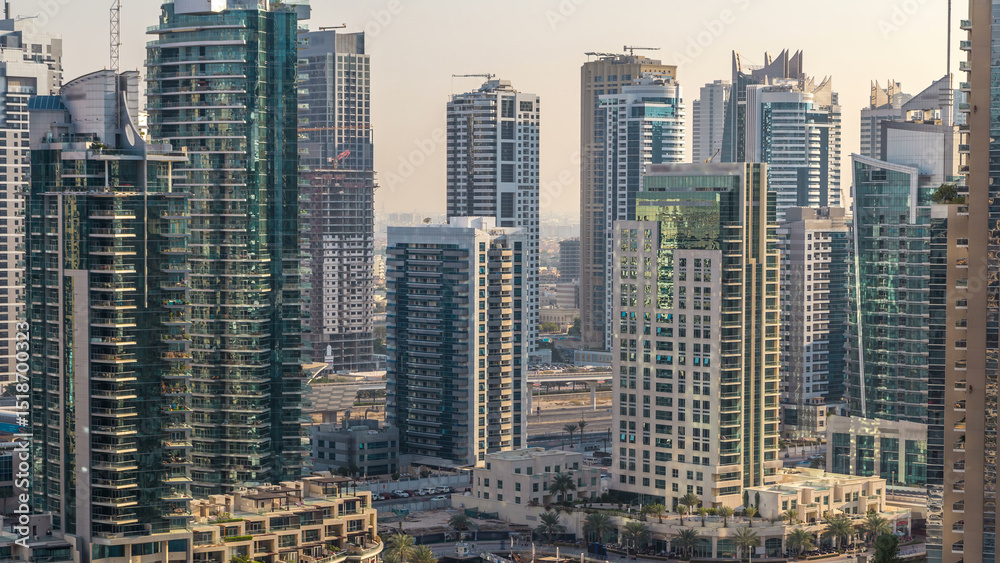 Fototapeta premium Beautiful aerial view of Dubai Marina promenade and canal with floating yachts and boats before sunset in Dubai, UAE.
