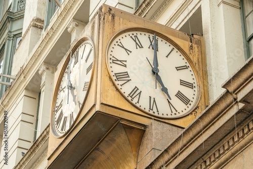 Wallpaper Mural The old corner clock on a New York City building shows the time with bold roman numerals. The metal structure has a weathered look adding to its character. Torontodigital.ca