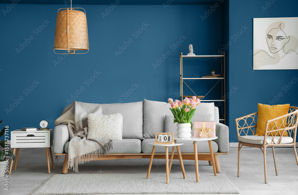 Fototapeta premium Interior of living room with gift box and tulips for International Women's Day on tables