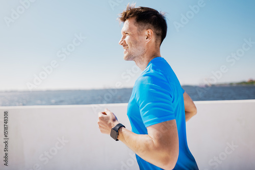 Running by the waterfront under a clear blue sky at midday, feeling the fresh air and freedom