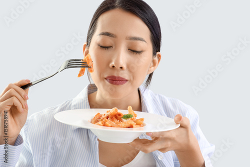 Young Asian woman eating ta...