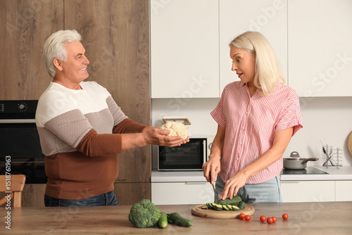 Mature couple cutting cucum...