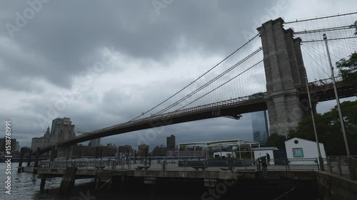 New York City, USA - May 21, 2025: A low angle view of the Brooklyn Bridge under cloudy skies.