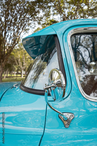 Fotomural Rear view mirror of a classic blue vehicle with chrome accents and front windshield
