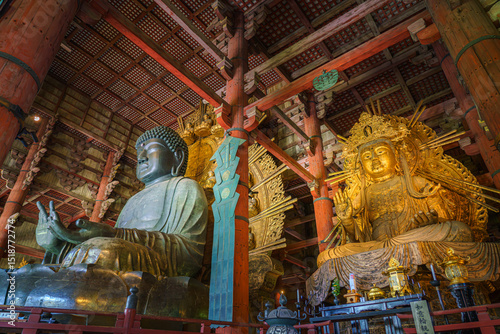 Nara, Japan - Sep 26 2024, Panoramic view of the Sitting Buddha Vairochana, a fifteen-meter bronze statue of Buddha, and a side-standing gilded statue of Buddha, at Todaiji Temple, Nara, Japan