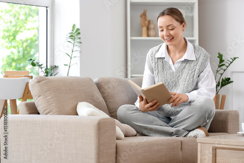 Smiling young woman reading...