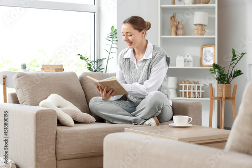 Smiling young woman reading...