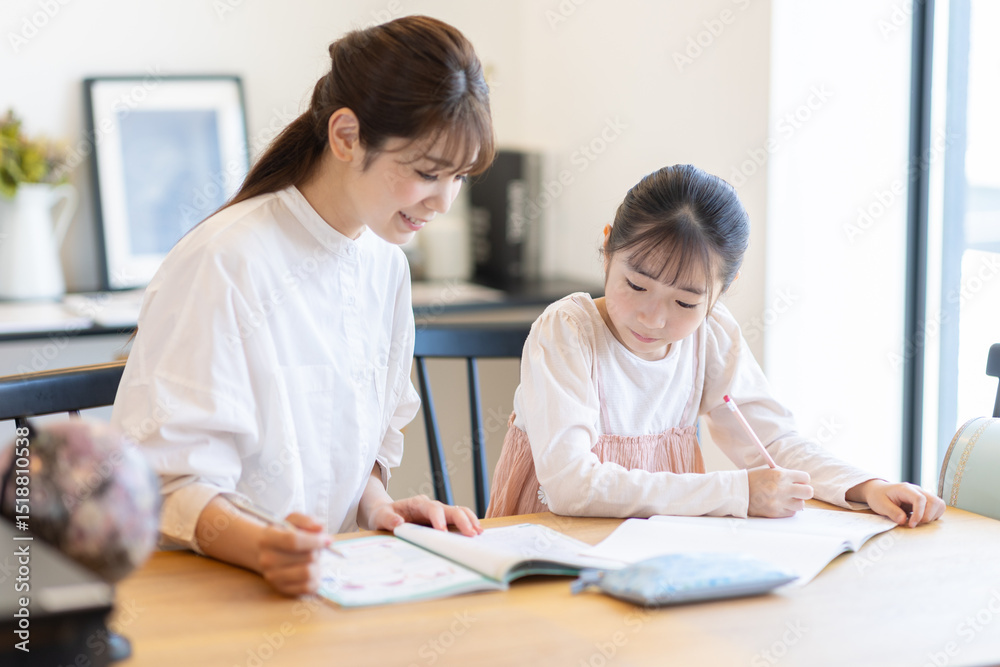 子供の勉強を見る母 子供の勉強を見る母
