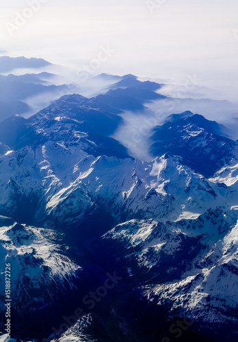 An aerial shot of the Swiss Alps mountain range on a sunny day with blue skies