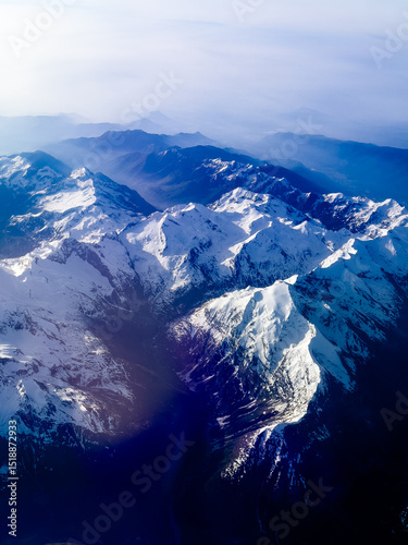 An aerial shot of the Swiss Alps mountain range on a sunny day with blue skies