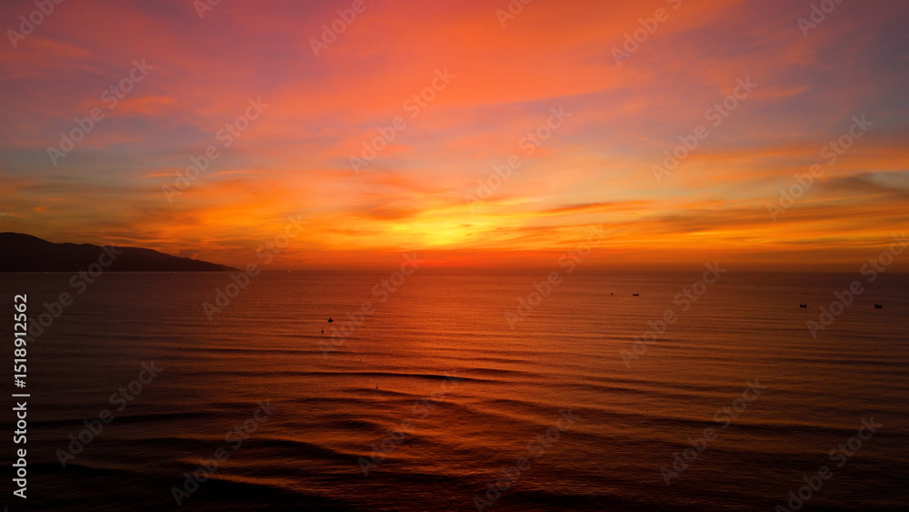 Fototapeta premium Golden sunrise painting the sky with vibrant hues over the calm ocean in da nang, vietnam, creating a breathtaking spectacle of nature's beauty