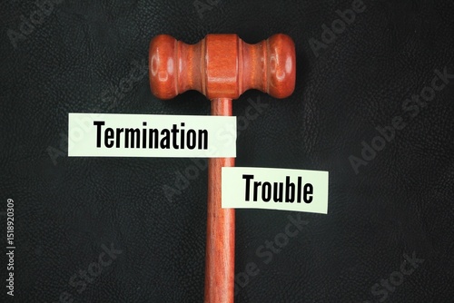 Judge's gavel and colored paper with the word termination trouble. refers to the difficulties or complexities that can arise when an employment contract is ended photo