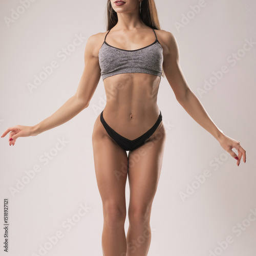 Fitness model showcasing strength and physique in a studio setting