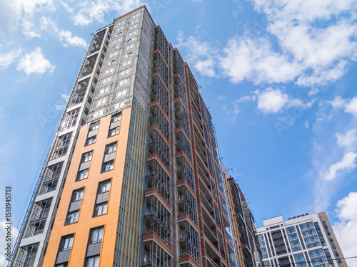Construction work on the exterior cladding. Laying of thermal insulation material on the walls. Insulation of a high-rise building. Plastering the walls. Balconies of a house under construction.