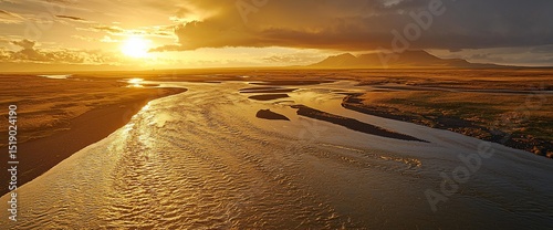 Golden sunset over a meandering river, vast plains, and distant mountains. Serene landscape bathed in warm light