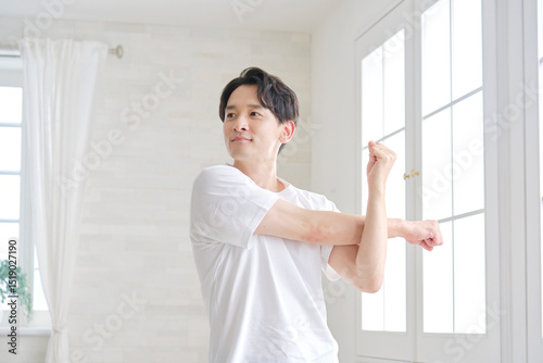 自宅で腕のストレッチする男性 photo