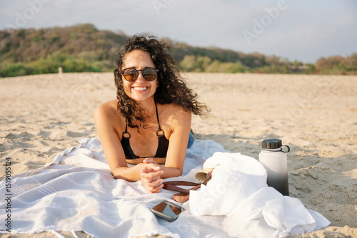 Traveler enjoying a sunny day at the beach wearing sunglasses and swimwear.