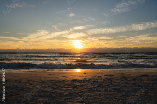 Sun sets while waves crash the shoreline of Holmes Beach